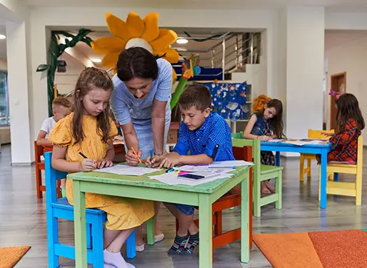 Docente acompañando al alumnado durante una actividad educativa en el aula