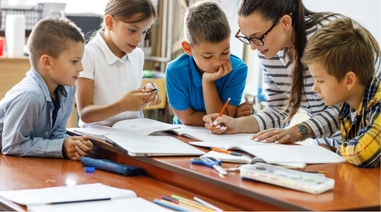 Docente acompañando a varios alumnos durante una actividad educativa