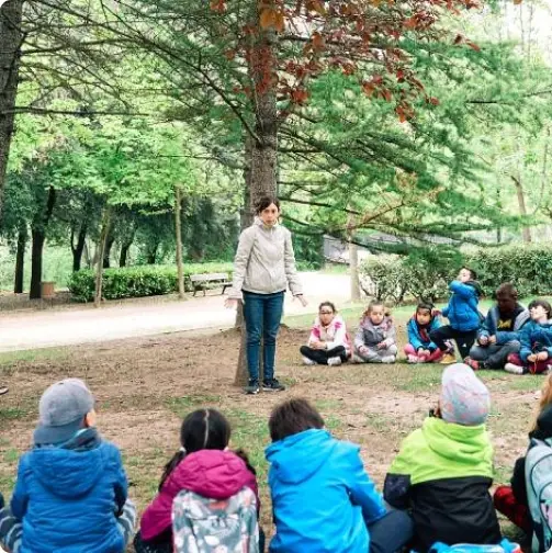 Docente realizando una actividad de educación ambiental con alumnado al aire libre