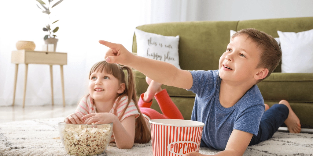 Niños viendo una película con palomitas
